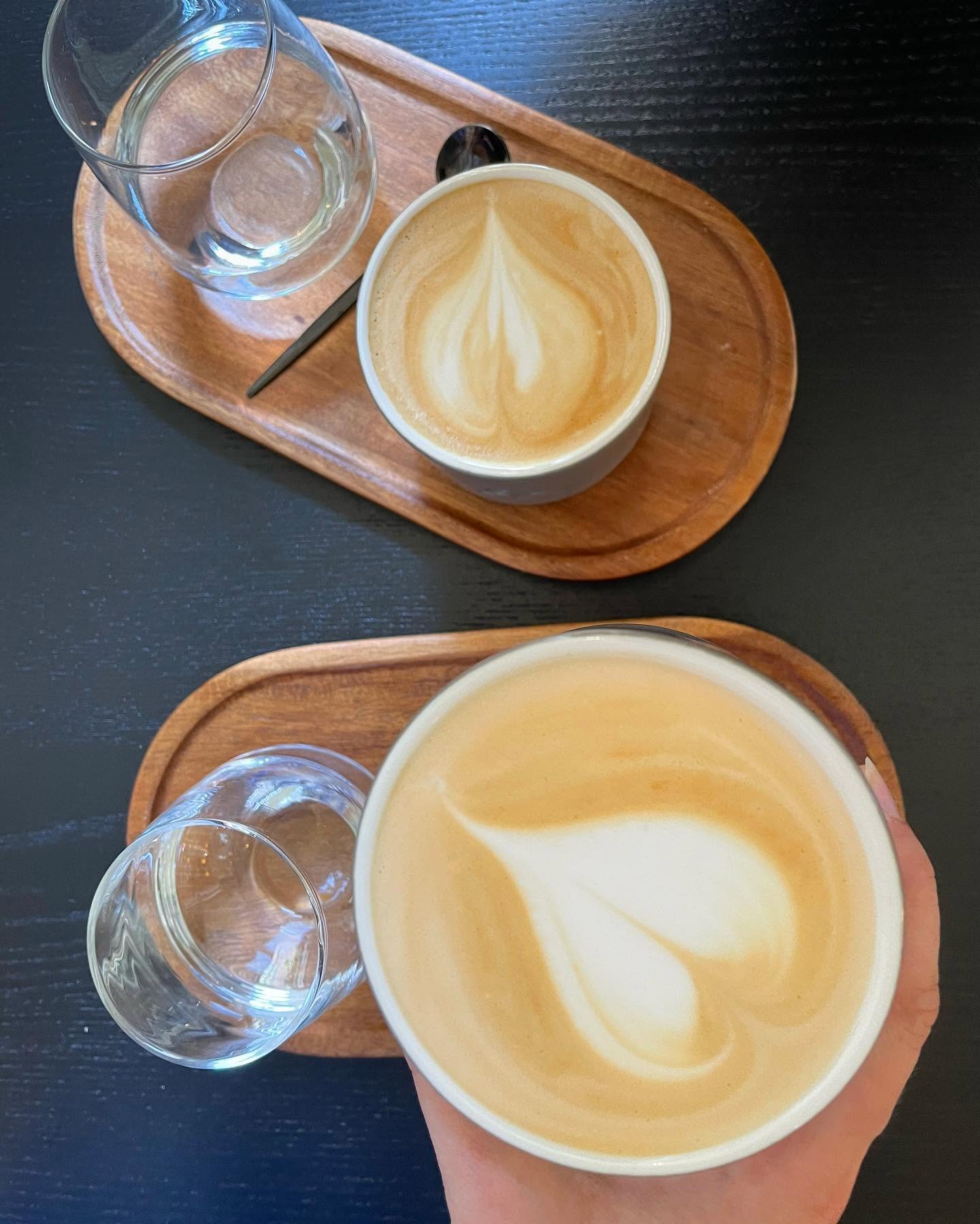 Two lattes on wooden trays